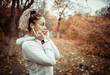 © splitov27 - Attractive sport blonde woman listens to music on headphones in autumn forest