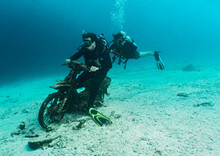 Divers Having Fun With A Sunken Motorcycle On A Dive Around Phuket