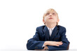 © somemeans - Elementary school student sits idly by at desk and looks up. Portrait of schoolboy in isolation on white background. Copy space.