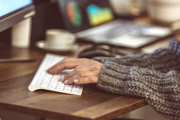 Fototapete - Close-up of female hands typing on a modern laptop keyboard and taking notes on a device, an older white woman's text message using a computer gadget at home, the concept of new technology