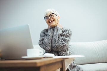 mature business woman teleconferencing from home. a happy business woman is sitting and talking to c
