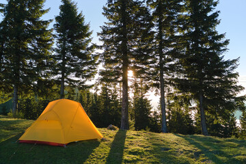 Wall Mural - Tourist camping tent on mountain campsite at bright sunny evening. Active tourism and hiking concept