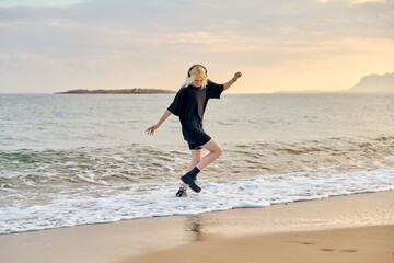 Hipster female teenager having fun on the beach at sunrise