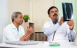 © WESTOCK - doctor explaining by seeing x-ray report to senior elderly patient at hospital - concep tof medical treatment, assistance and Healthcare