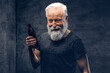 © Fxquadro - Studio shot of glad grandfather dressed in shirt with modern hairstyle against dark background.
