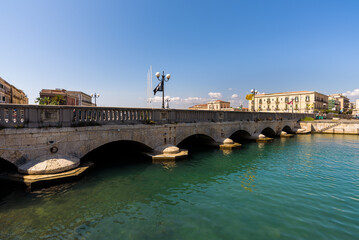 Wall Mural - Syracuse, Sicily. View of the strait of water between mainland Siracusa and the island of Ortigia. They are linked by the Umbertino Bridge and the Santa Lucia Bridge.