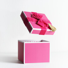 Empty Open Pink Gift Box With Ribbon And Flying Lid At White Background. Levitation Concept Present Box. Front View With Copy Space.
