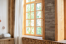 Big Wooden Window With Frame And Window Sill And Nature On Background. Empty Room, Wooden Window With With White Linen Curtain And Logs Decoration Wall On A Sunny Day Indoor Shot. Scandinavian Room