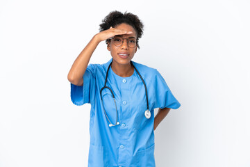 Sticker - Young surgeon African American doctor woman isolated on white background looking far away with hand to look something