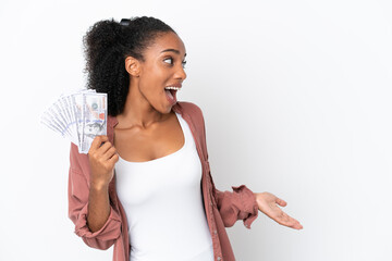 Young African American woman taking a lot of money isolated on white background with surprise expression while looking side