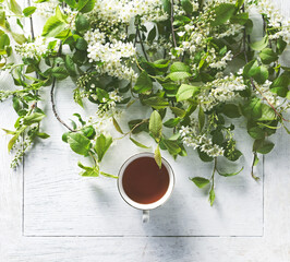 Sticker - An arrangement of white spring blossom with a cup of tea. Top view