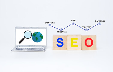 a picture of miniature laptop with magnifying and earth insight. seo on wooden block. context, analy