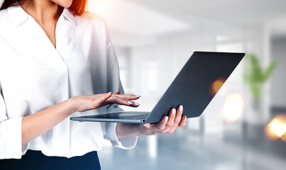 Poster - Businesswoman wearing formal wear is holding laptop standing at