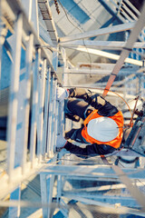 Wall Mural - A heavy metal industry worker climbing up the metal construction.