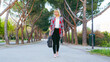 © MARALEM - Emprendimiento de la mujer  en la era moderna, mujer de negocios caminando por el parque, chica rubia con zapatillas rosas y una maletín en la mano
