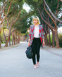 © MARALEM - Emprendimiento de la mujer  en la era moderna, mujer de negocios caminando por el parque, chica rubia con zapatillas rosas y una maletín en la mano