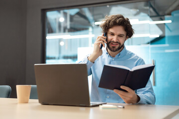 Sticker - Business man talking on phone at office, reading diary