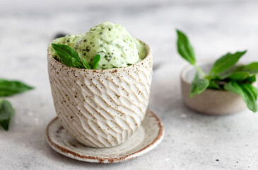 vegan spinach coconut ice cream in ceramic bowl on gray background. Healthy green dessert