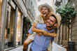 © Davide Angelini - Couple of tourists having fun walking on city street at holiday - Happy friends laughing together on vacation - People and holidays concept