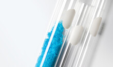Blue Flake Chemicals In Test Tube, Copper(II) Sulfate. Cosmetic Chemicals Ingredient On Blue Background. Close Up