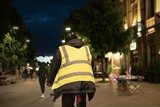 Fototapeta Sawanna - Pavement Pedestrian Walkway in a Night Park with cyclist on the background