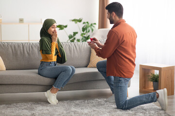 Wall Mural - Muslim Man Proposing To Woman Offering Engagement Ring At Home