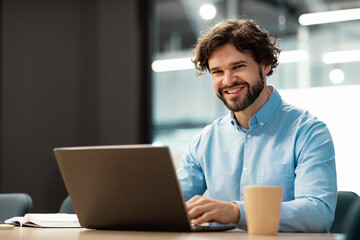 Aufkleber - Portrait of smiling Arab man using laptop and posing