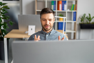 Aufkleber - Positive mature businessman gesturing to webcamera while having video call, working in modern office