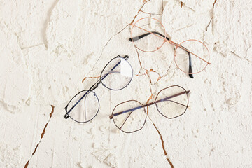 Wall Mural - three stylish modern eye glasses on cracked background