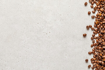 Wall Mural - Organic coffee beans border over light stone background. Copy space for text
