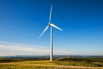 Wall Mural - wind turbines on a beautiful blue sky in a mountain wind farm in sardinia. renewable energy concept,