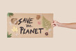 Hand holds a handmade cardboard with an inscription: Save the planet.