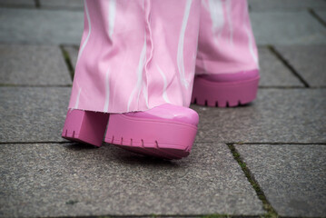 Closeup of pink shoes on woman standing in the street