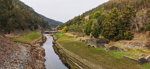 Wall Mural - Dry riverbed, with arid and cracked soil because of drought, due to climate change