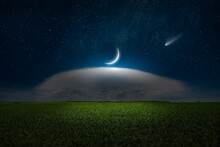 Dark Mysterious Background: Crescent Moon Illuminates White Cloud In Dark Blue Night Sky. Comet And Bright Stars Over Green Field.