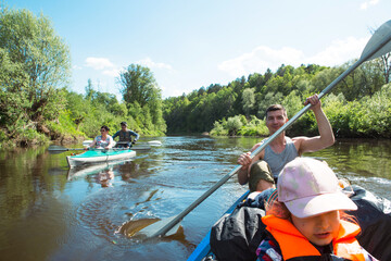  Family kayak trip. Father and daughter, and elderly couple senior and seniora rowing boat on the river, a water hike, a summer adventure. Eco-friendly and extreme tourism, active and healthy lifestyle