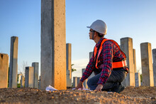 Construction Engineers Survey Checkpoints Of Concrete Pile,  Load-bearing Piles Of The Tall Building At The Construction Site Evening Time.
