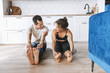 © shunevich - Smiling young sporty couple practicing yoga lesson, doing upward facing dog exercise, Urdhva mukha shvanasana pose, working out, indoor full length, looking at each other on the apartment floor