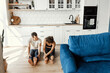 © shunevich - Couple exercising together on the modern kitchen floor. Man and woman in sports wear doing workout at home. Caring girl helping her boyfriend to do stretching