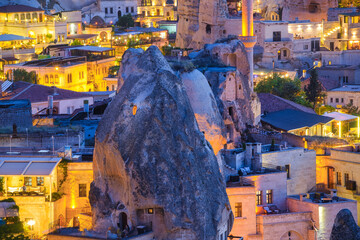 Goreme, Cappadocia, Turkey. View of the evening city from the mountain. Bright evening city. Landscape in the summertime. UNESCO heritage. Vacation and tourism.