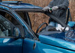 worker replacing a broken wind shield  on a car