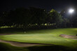 Beautiful dark night view of the golf course, Bunkers sand and green grass, garden background In the light of the spotlight underexposure view.