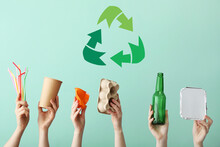 Hands With Garbage And Symbol Of Recycling On Color Background