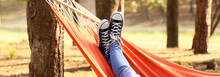 Legs Of Young Woman Relaxing In Hammock Outdoors