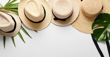 Summer Straw Hats With Tropical Leaves On Light Background With Space For Text