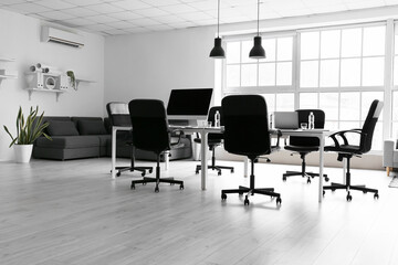 Poster - Interior of light office with table, chairs and sofa