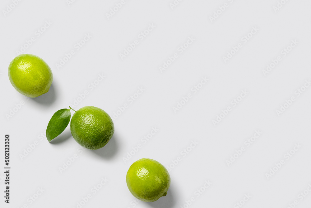 Fresh juicy limes on light background
