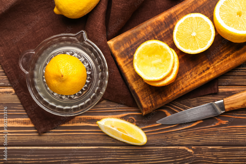 Composition with juicer and ripe lemons on wooden background