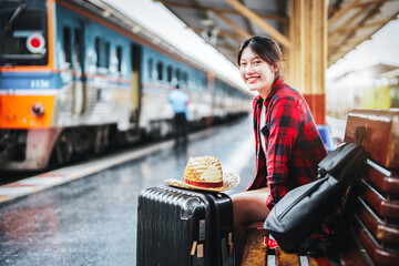 Wall Mural - summer, relax, vacation, travel, portrait of  cute Asian girl showing smile and waiting at the train station for a summer trip.