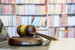 Legal office of lawyers, justice and law concept : Judge gavel or a hammer and a base used by a judge person on a desk in a courtroom with blurred weight scale of justice, bookshelf background behind	